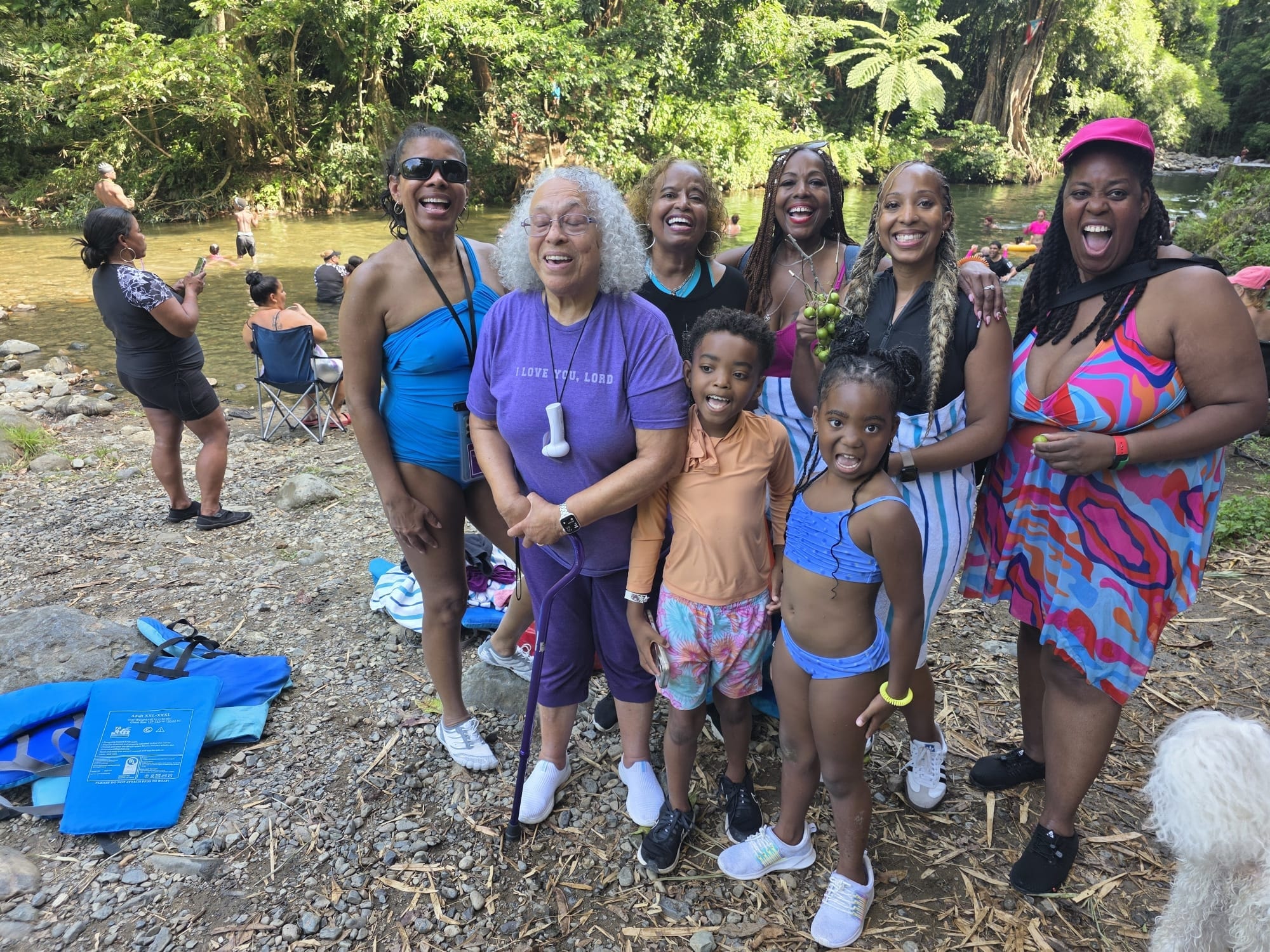 Large family group smiling by the river on a Manny's Tours adventure